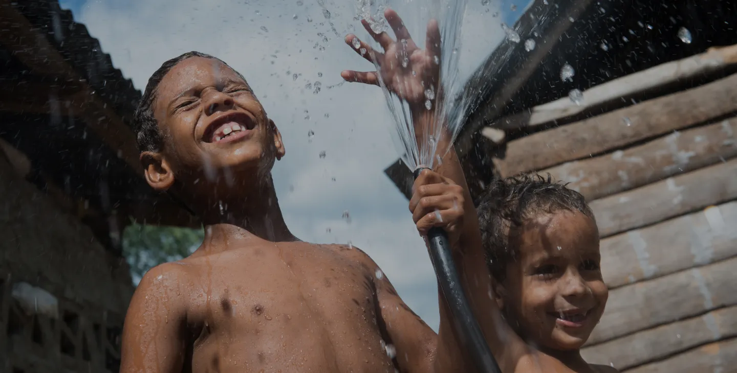 Niños disfrutando del agua que sale de una manguera