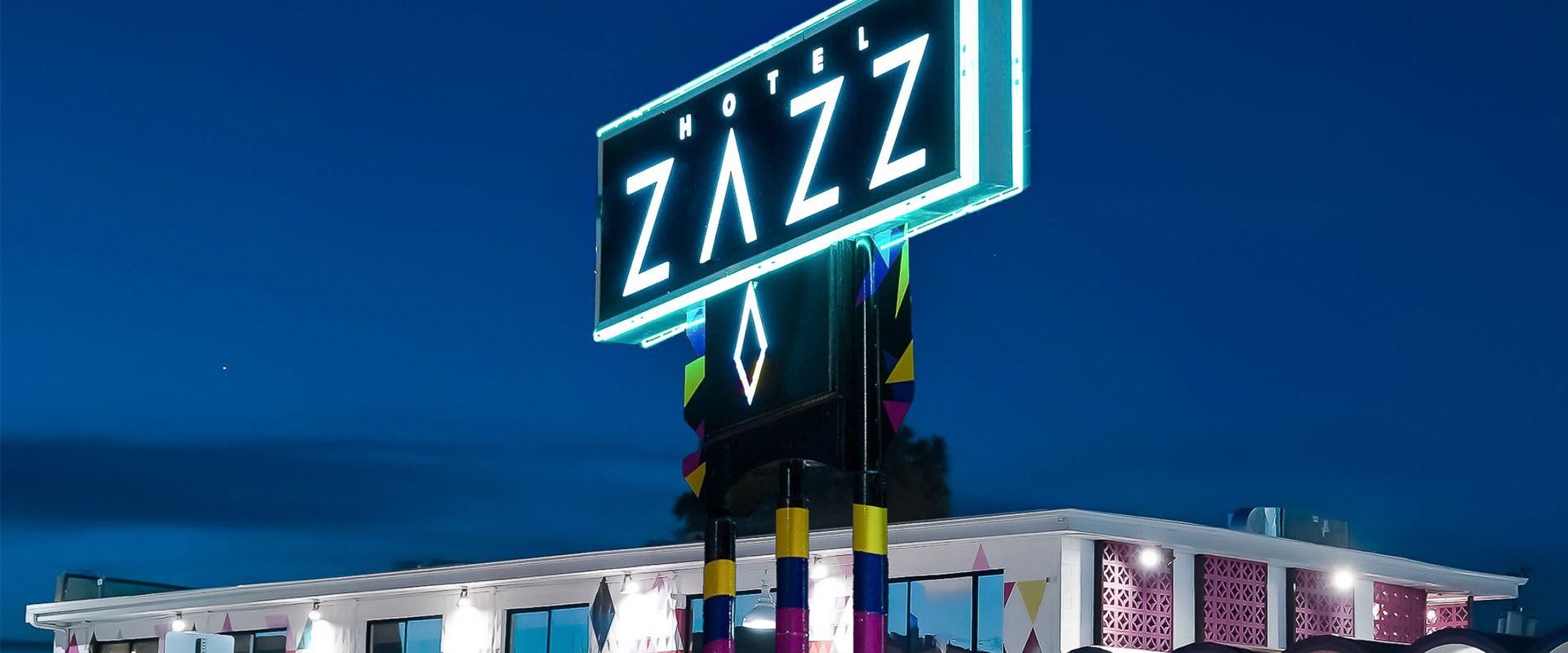 The Hotel Zazz neon sign glowing at dusk