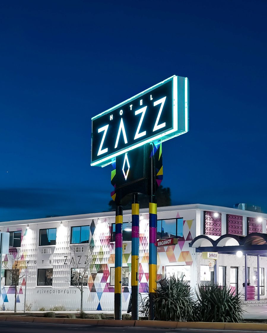 The Hotel Zazz neon sign glowing at night over the colorful hotel on Route 66