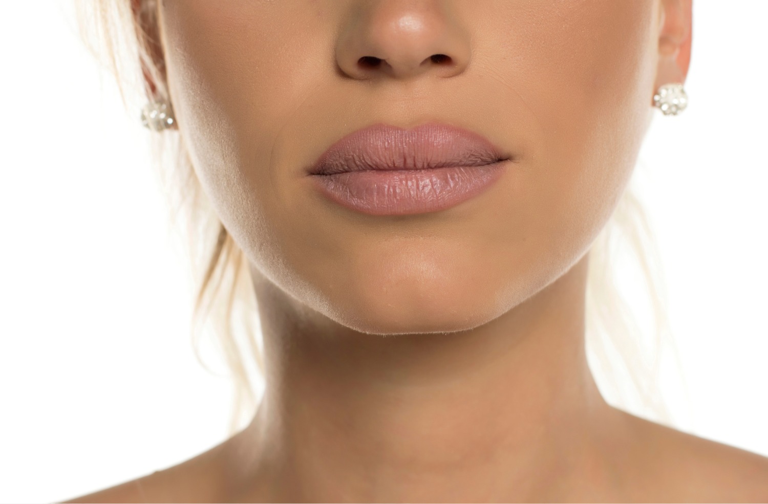 Close-up of a woman's lower face showing smooth skin and lips with natural-tone lipstick.