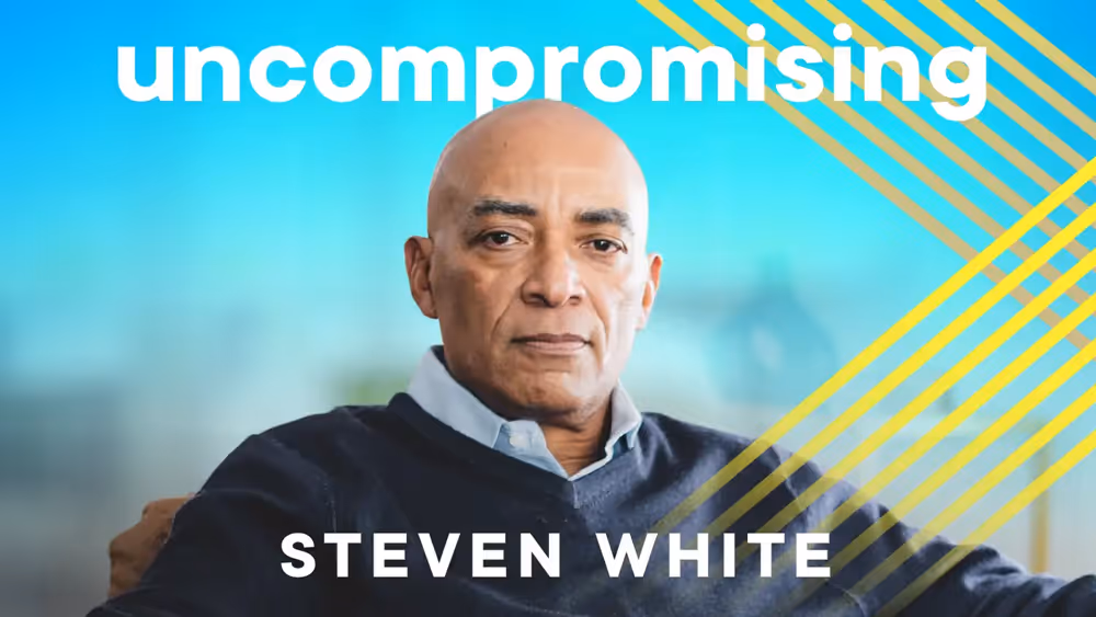 Portrait of serious bald man in navy sweater with text 'uncompromising' and name 'Steven White' over blue background.