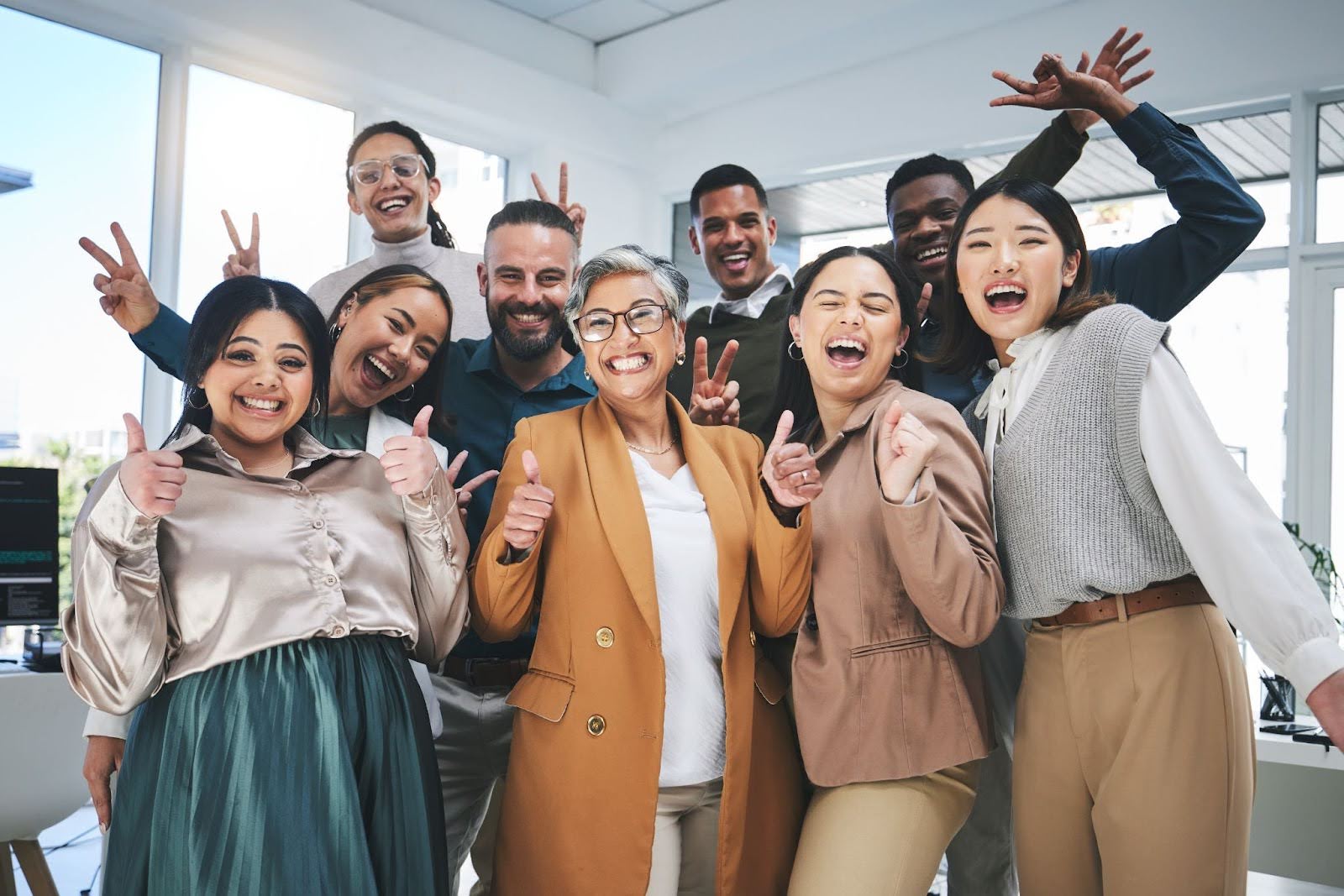 Happy group of engaged employees acting fun and silly together