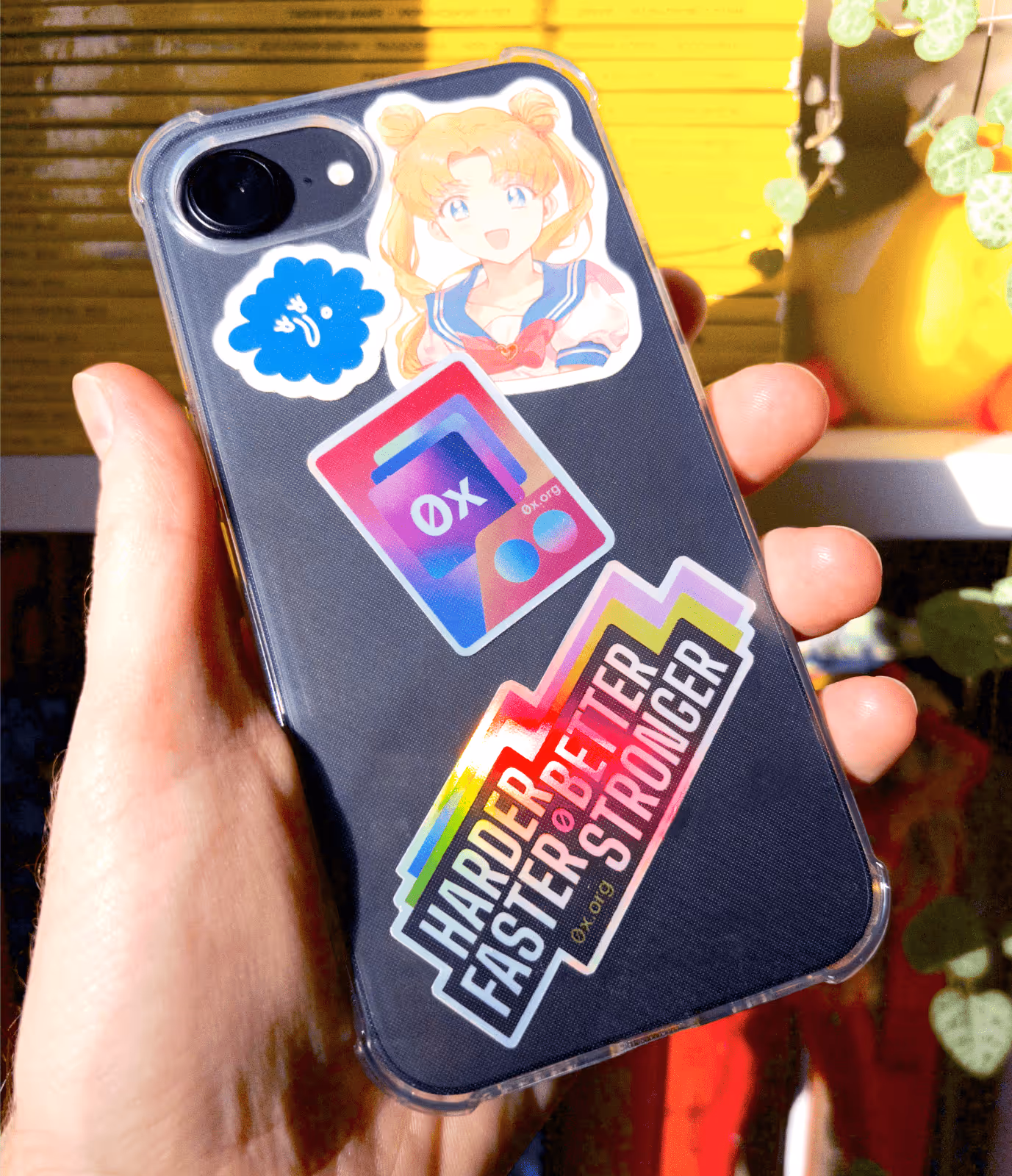 iPhone case decorated with 0x.org stickers and Harder Better Faster Stronger design