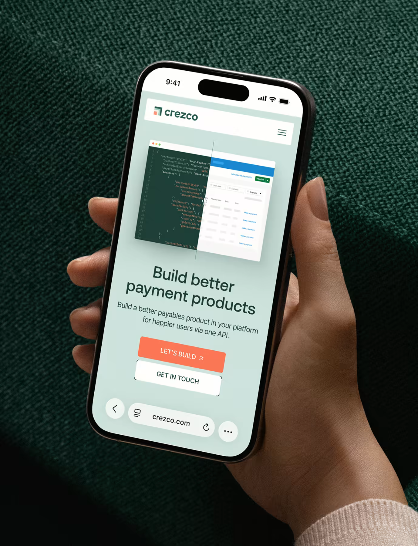 Hand holding a phone displaying the Crezco website hero "Build better payment products", showing API code transitioning into a payments dashboard