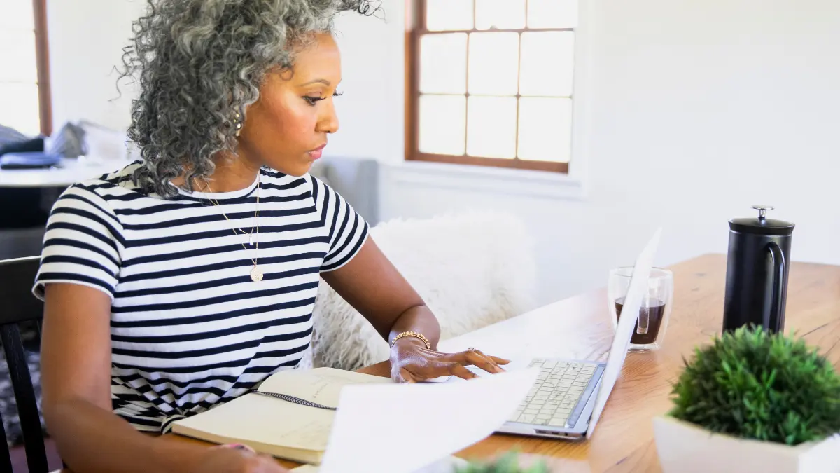 Midlife professional working at a laptop, representing women navigating menopause at work.