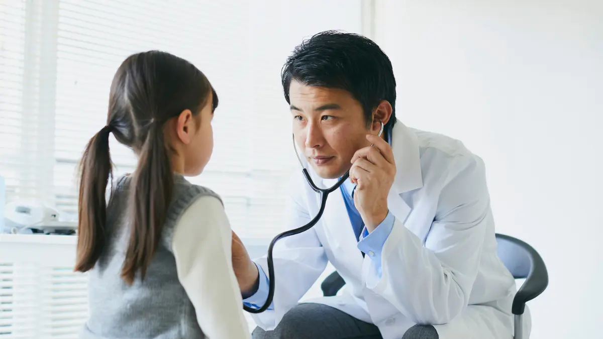 Primary care doctor conducting a preventive care exam for a child during a wellness visit.