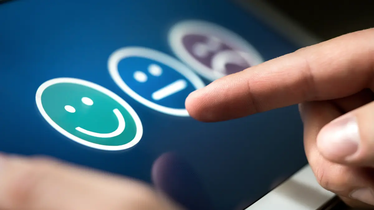 Person selecting a satisfaction rating on a digital survey, representing employee listening for benefits strategy.