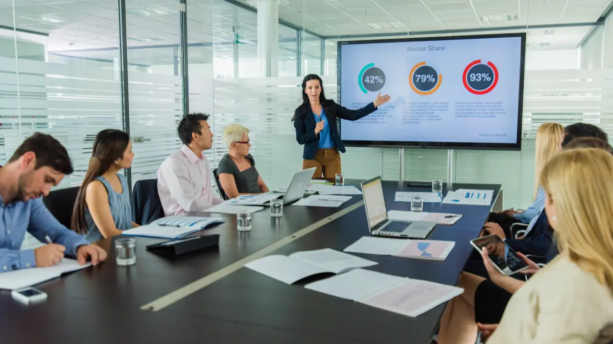 HR leader presenting financial data to a leadership team in a boardroom, making the business case for employee benefits investment