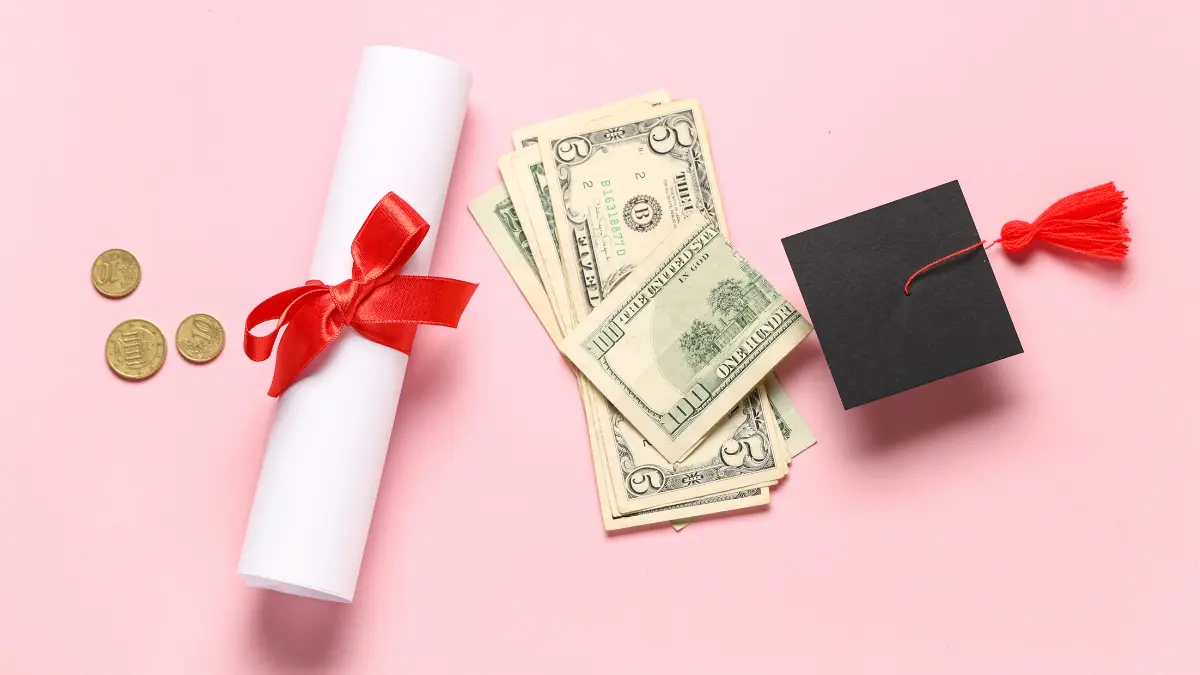 A diploma, stack of money, and a graduation cap on a pink background, representing employer student loan repayment benefits.