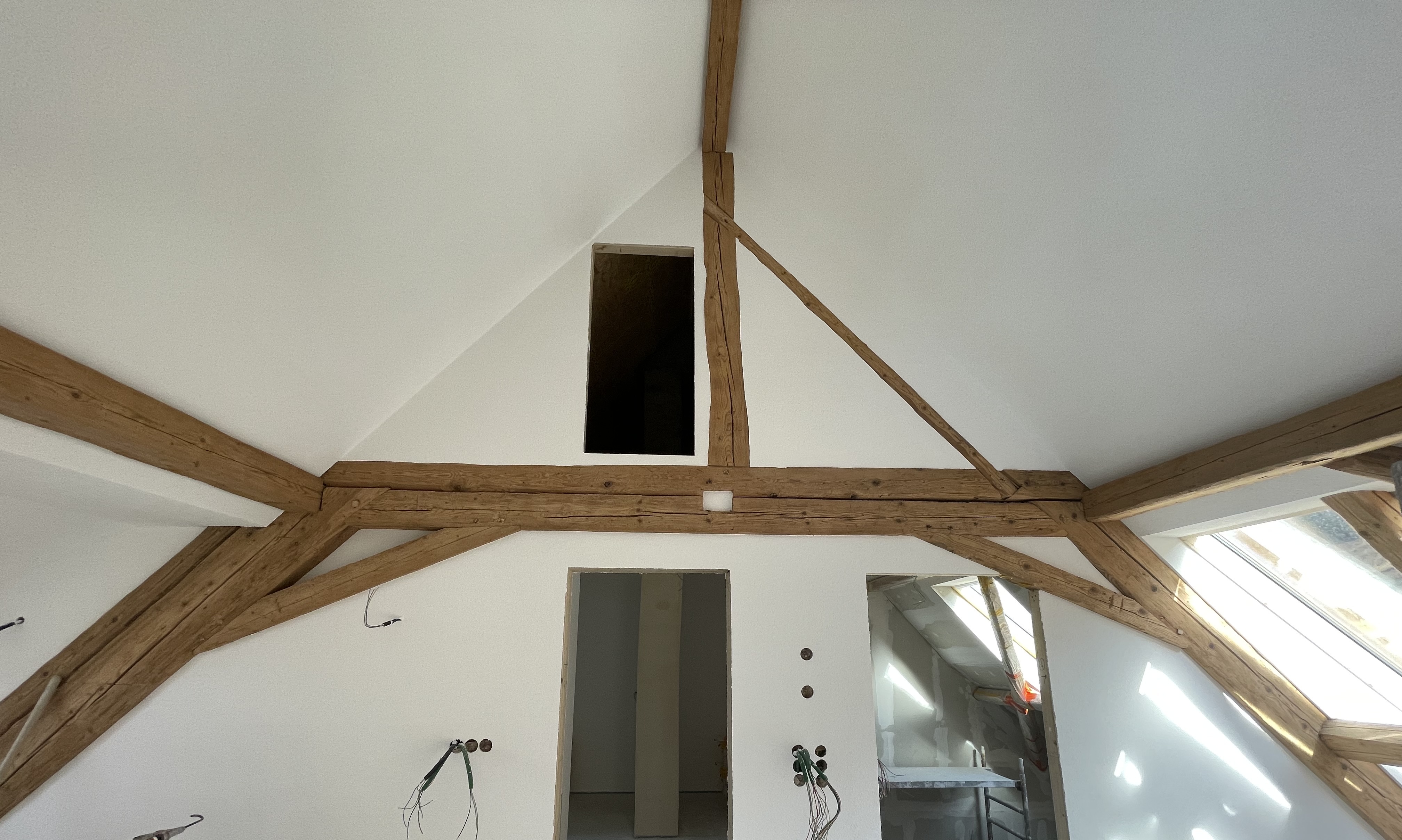  Ein Dachgeschoss mit freigelegtem Fachwerk und großen Dachflächenfenstern, im Ausbauzustand.