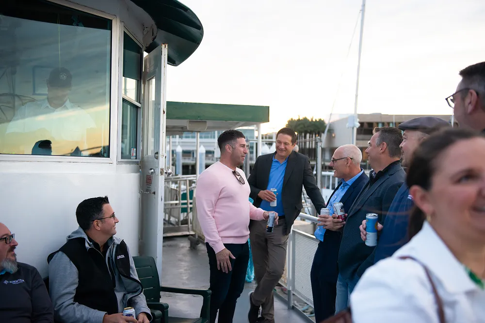Attendees enjoy casual networking on a boat during the HawkSearch Customer Summit 25 social event.