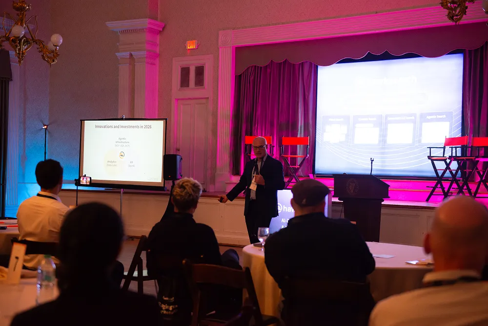 Ari Kahn presents at the HawkSearch Customer Summit 25, discussing innovations and investments for 2026 before an engaged audience.