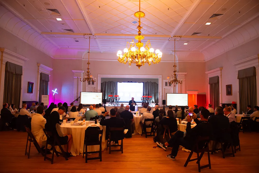 Attendees listen to a presentation in a chandelier-lit ballroom during the HawkSearch Customer Summit 25