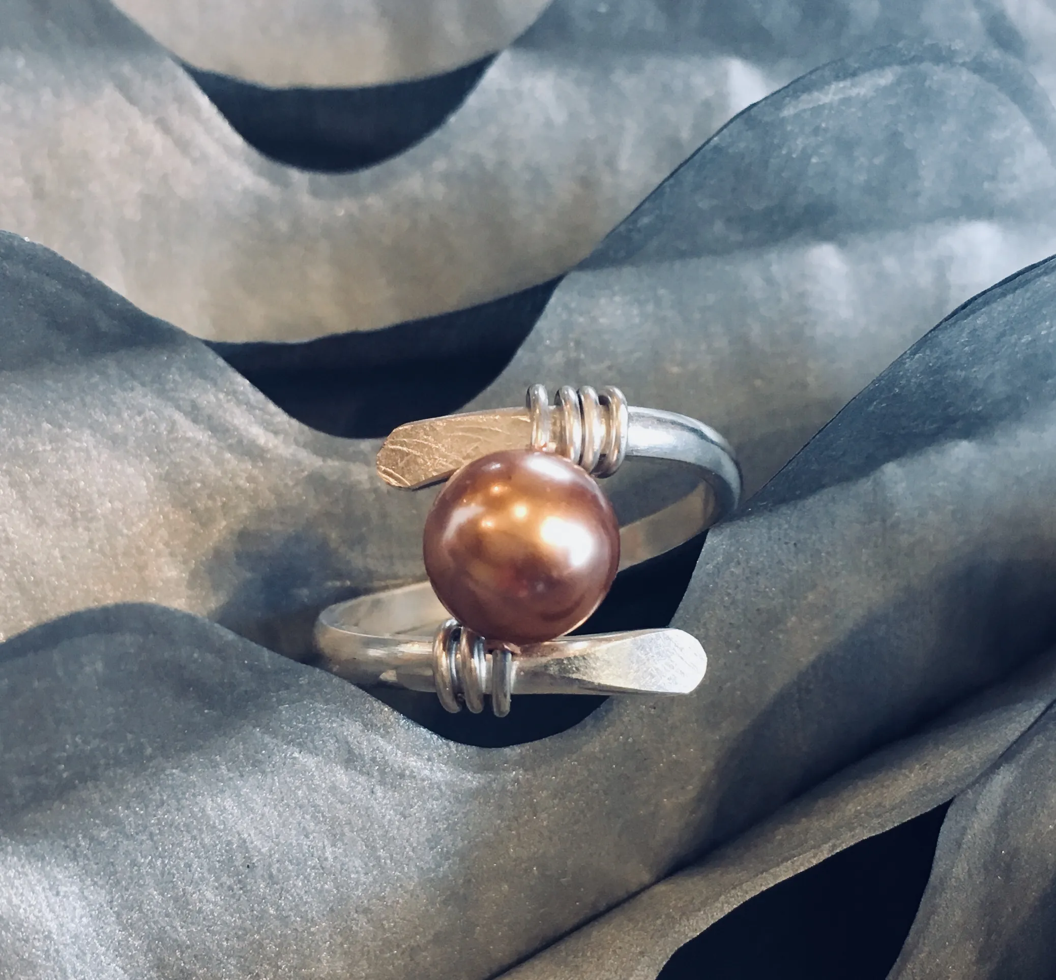 finished pearl ring on silver wave background