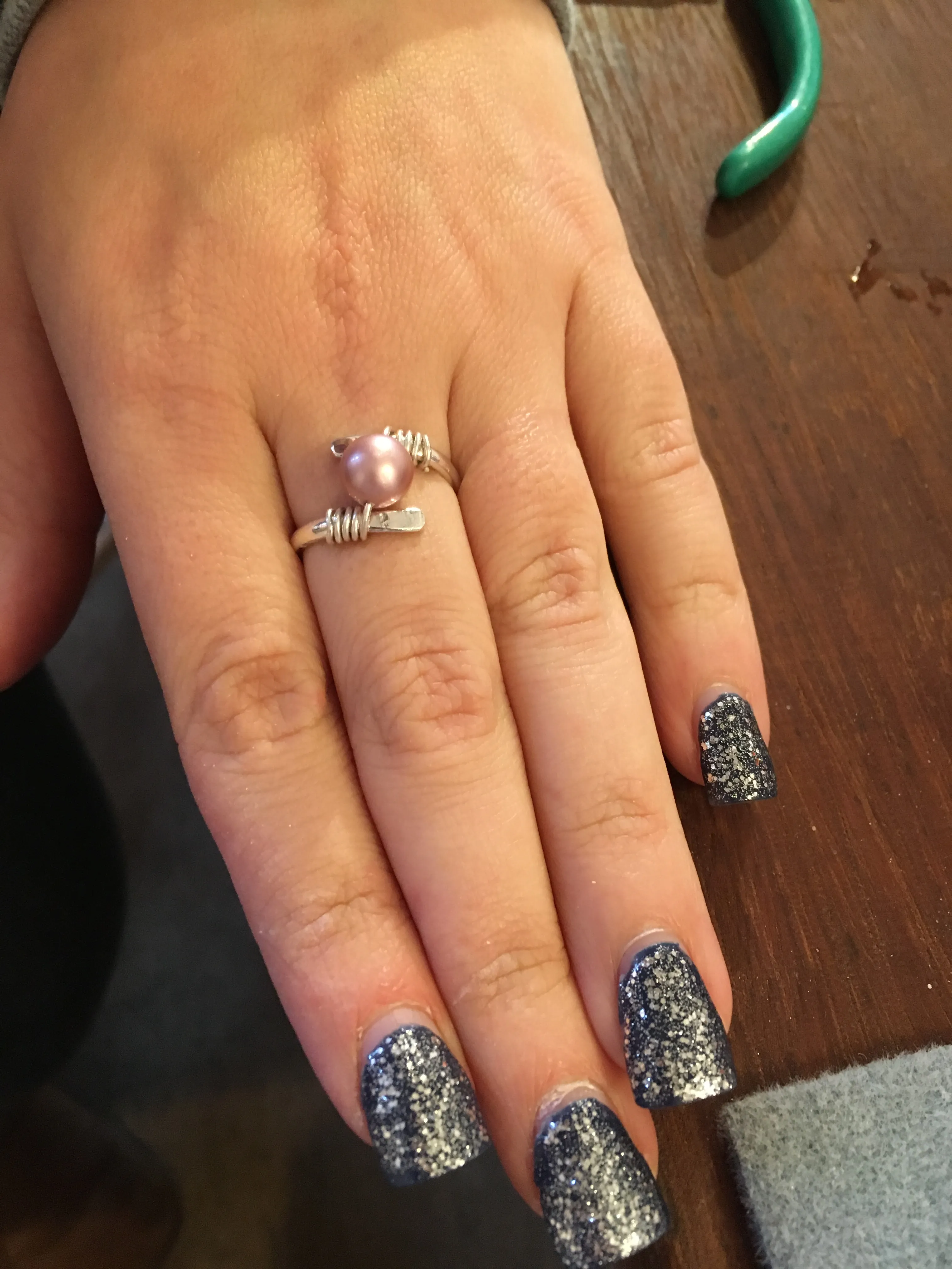 pearl ring on hand with tools in background