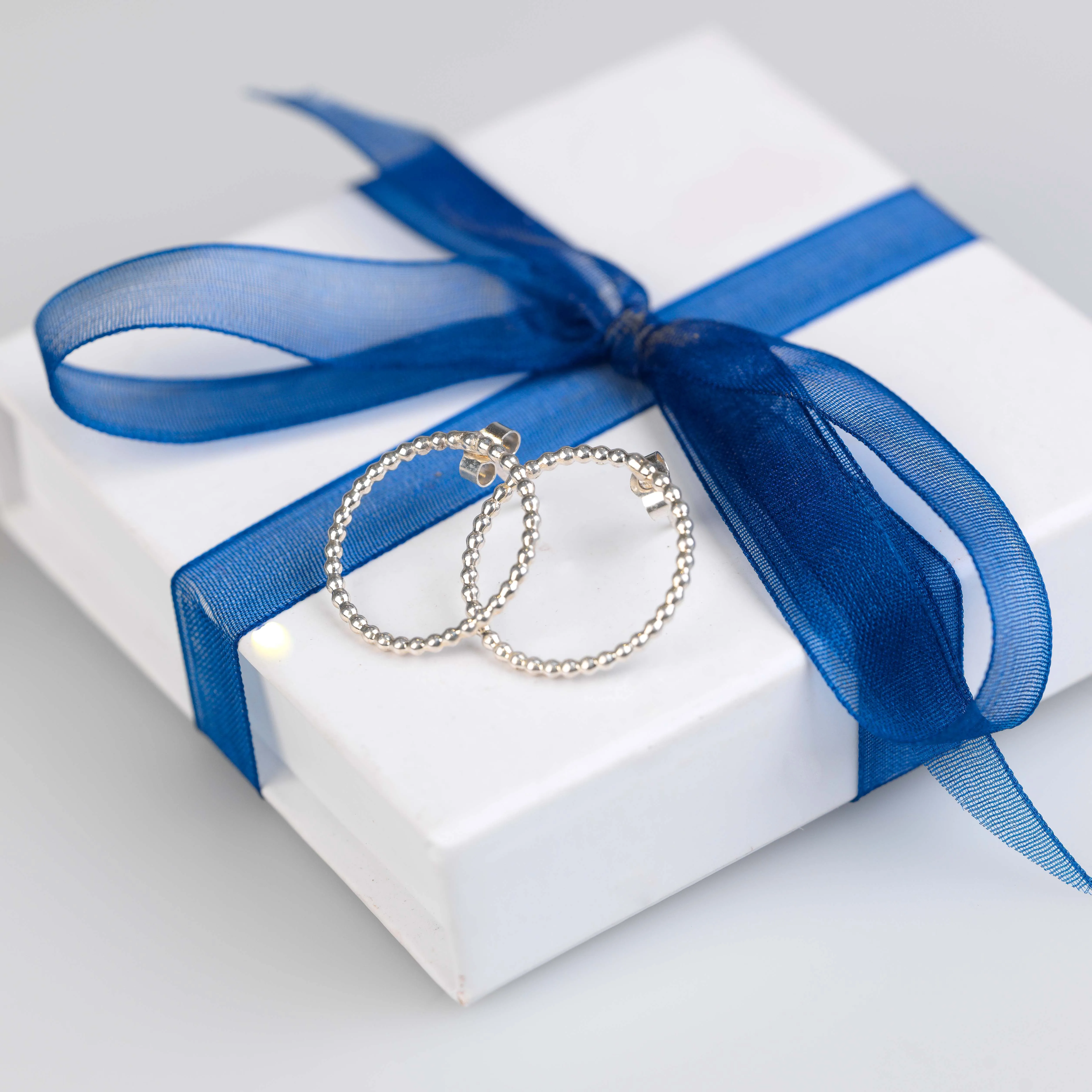 silver beaded hoop stud earrings with white jewellery box tied with blue ribbon