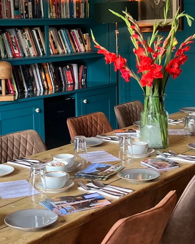meeting room at Barack House Great Massingham with red gladioli and table laid for meeting