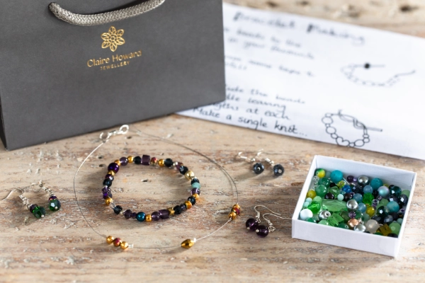 Jewellery making kit including instructions and coastal bead kit, photo also shows gift bag and finished examples on a wooden table