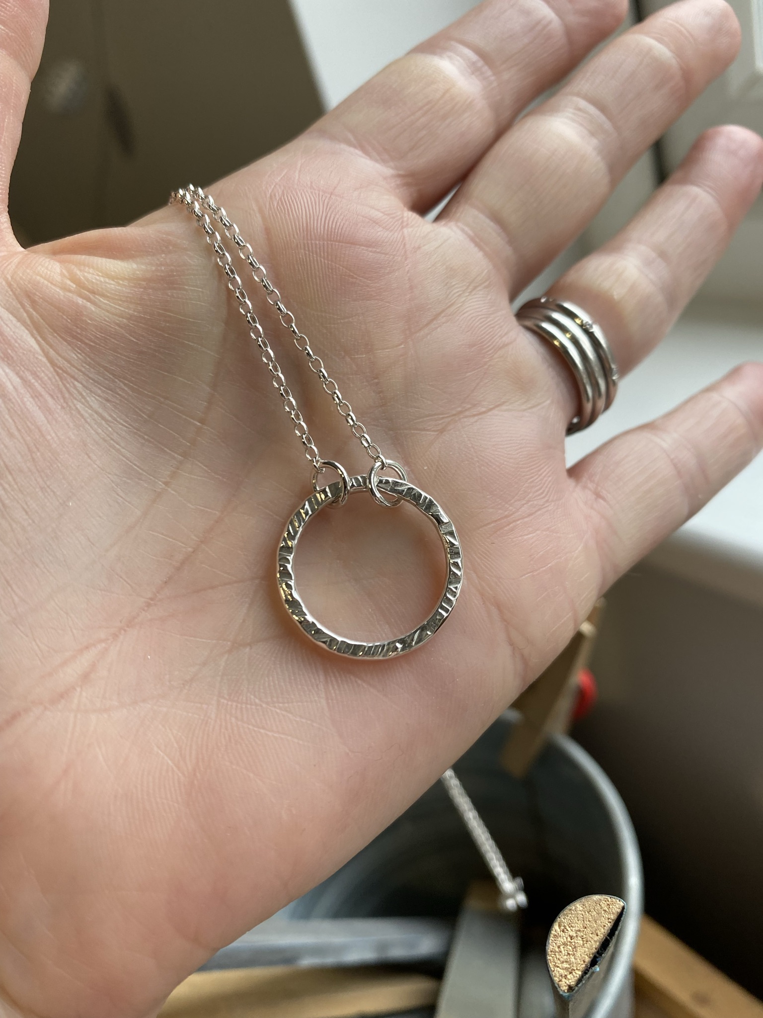 Before and after polishing a silver necklace showing tarnish removal