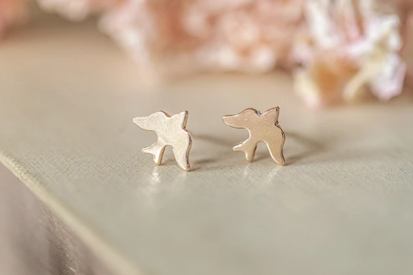 Small golden swallow studs handmade in Norfolk—perfect for second piercings, travel adventures, or new beginnings. Gift-wrapped in white jewellery box with ribbon.