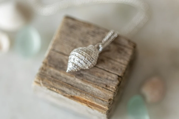 A sterling silver whelk shell necklace, cast from a real Norfolk beach find. Handmade in Norfolk—your perfect coastal keepsake, beautifully gift wrapped.