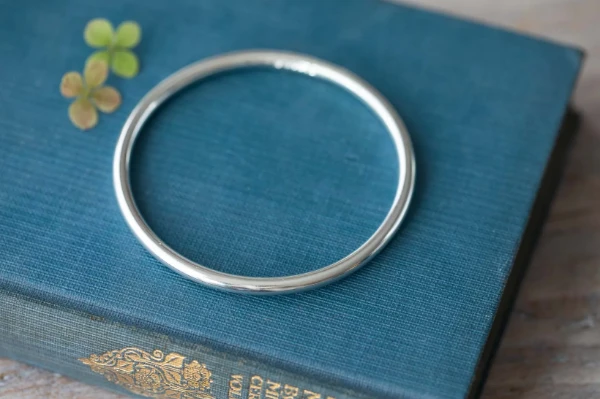 A handmade sterling silver bangle in solid 4mm wire—beautifully simple, weighty, and perfect for everyday wear. A timeless essential with quiet charm.