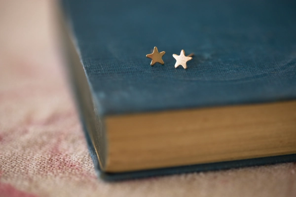 A mini gold-filled star on a sterling silver post with a silver scroll—perfect for young relatives or second piercings. Presented in a gift box with ribbon.