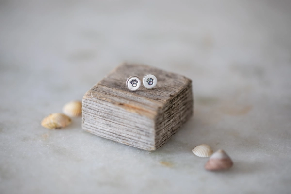 Handmade sterling silver stud earrings with a stamped paw print, perfect for new puppy owners or in memory of a beloved dog. Made in North Norfolk.