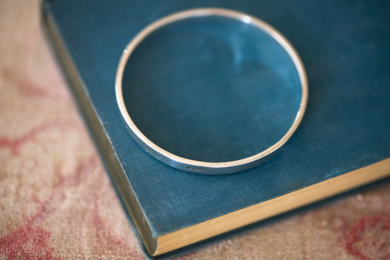 personalised bangle resting on vintage blue book