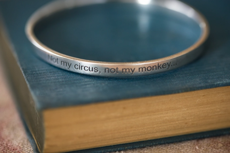 personalised silver bangle resting on vintage blue book