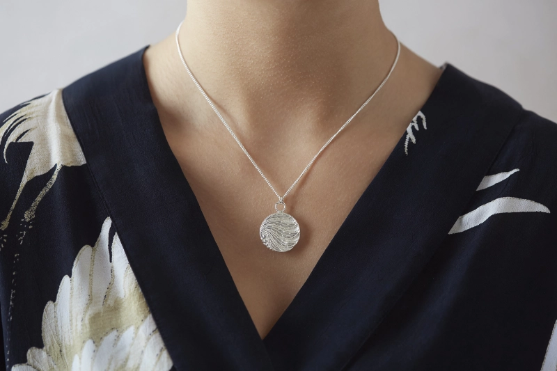 silver art deco button necklace worn on woman with black top