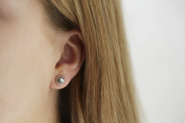 silver scallop shell stud earrings worn by model with long brown hair