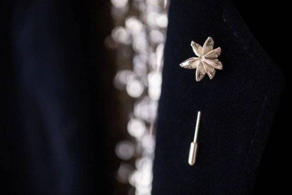 star anise pin on black cord jacket