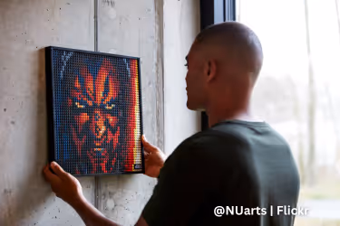 NUarts Studios - Man hanging a piece of art