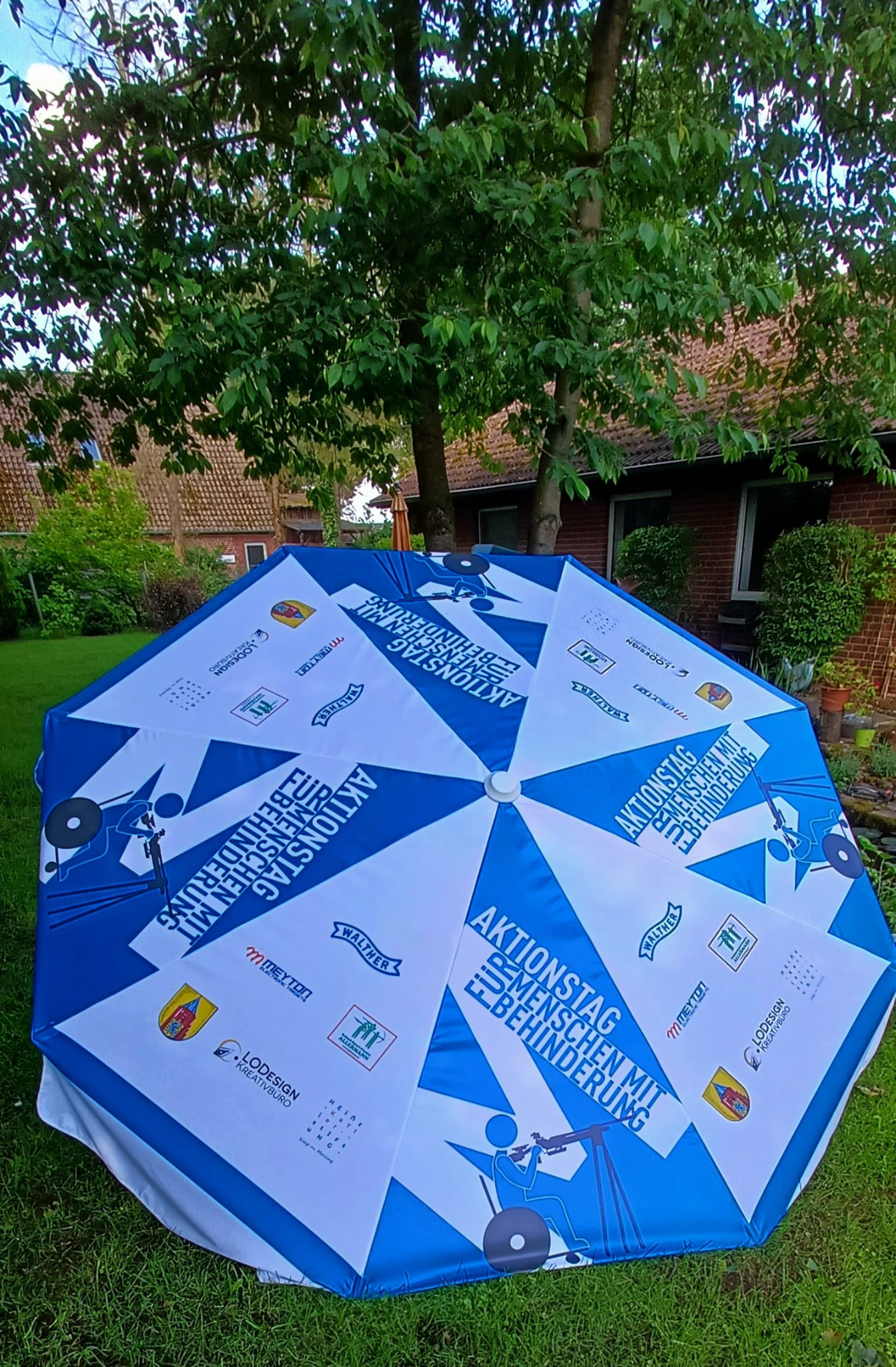 Bedruckter Sonnenschirm zum Aktionstag für Menschen mit Behinderung im Garten
