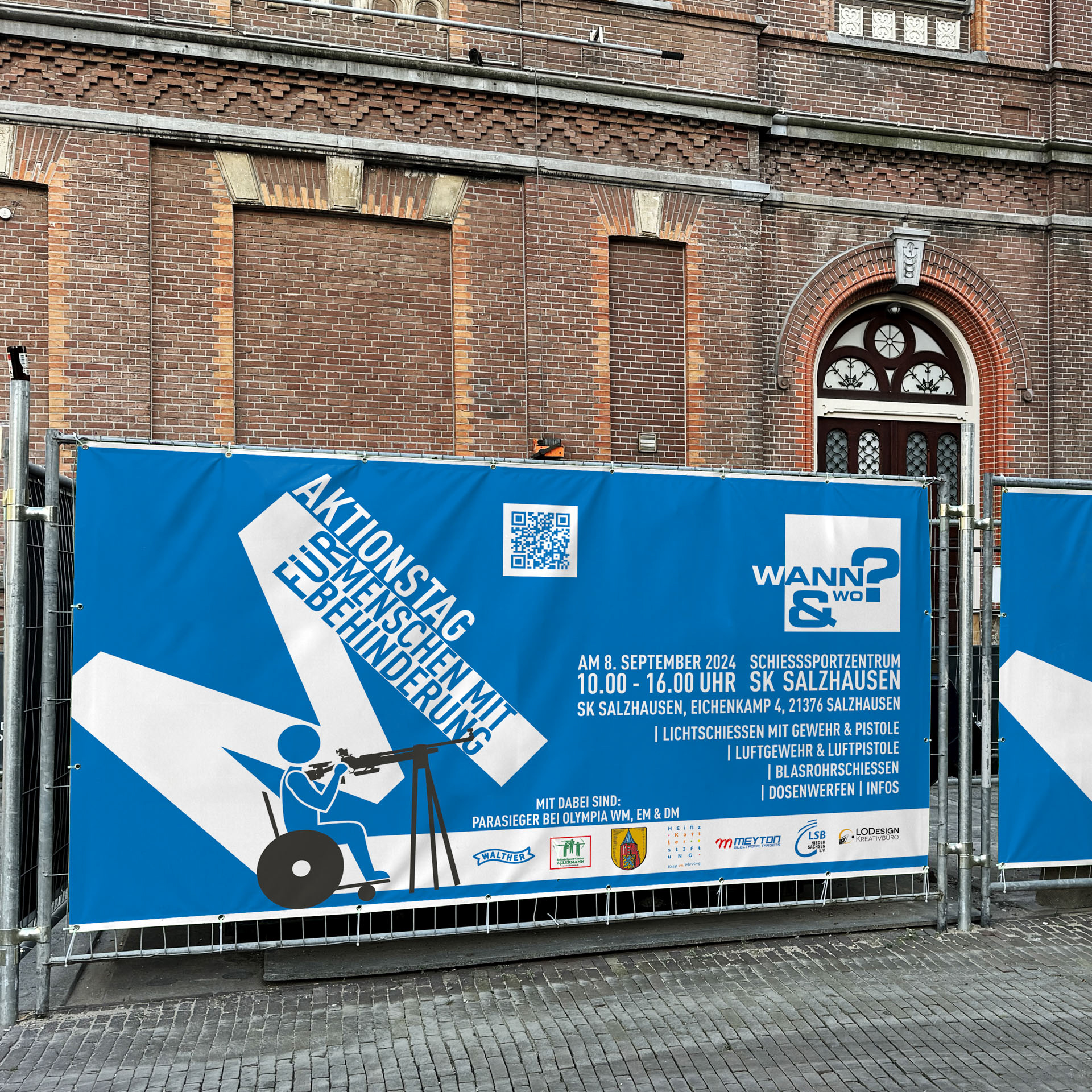 Bauzaunbanner zum Aktionstag vor einem Backsteingebäude