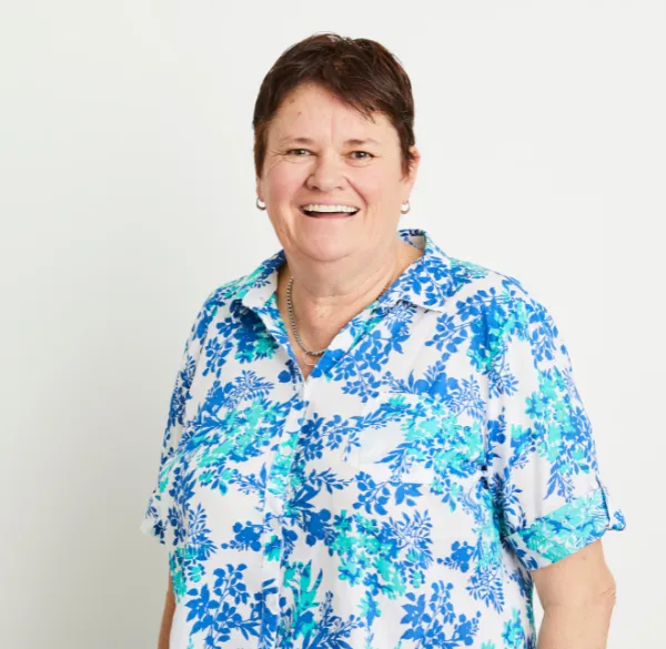 A woman dressed in a blue and white floral shirt, seeking knowledge about All-on-4 dental procedures