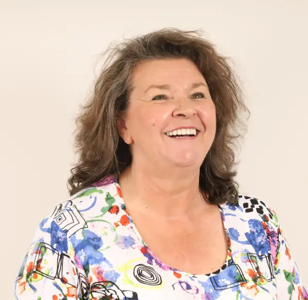 A woman dressed in a blue and white floral shirt, seeking knowledge about All-on-4 dental procedures