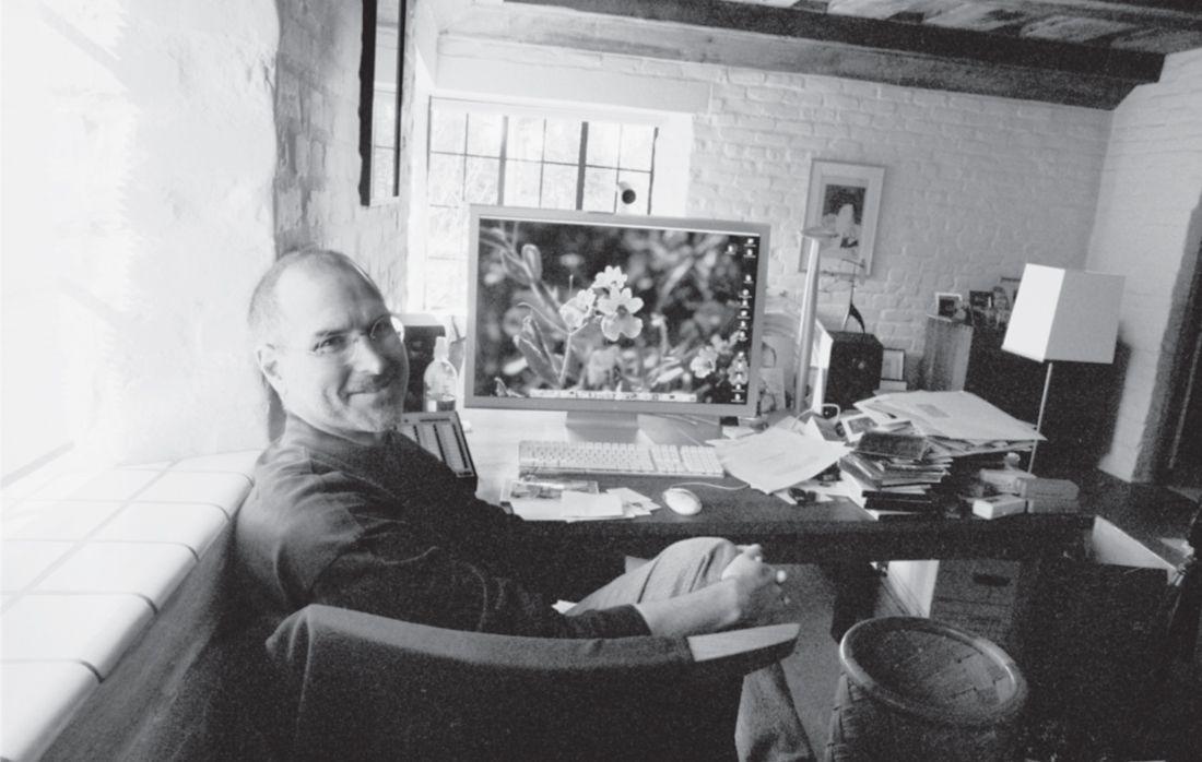 Steve Jobs sitting at a Thos. Moser desk in his home office