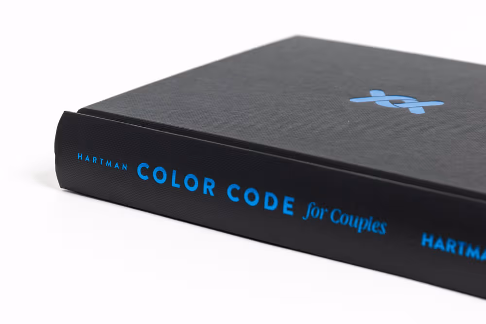 Black hardcover book titled 'Color Code for Couples' by Hartman with blue text on the spine and a blue symbol on the cover.