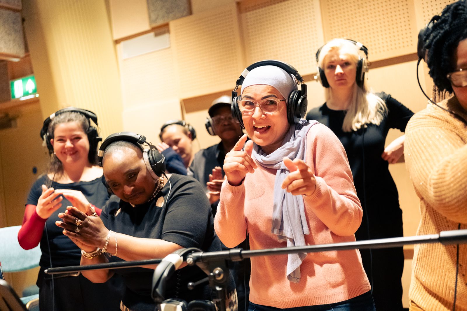 Choir members in headphones in the recording studio