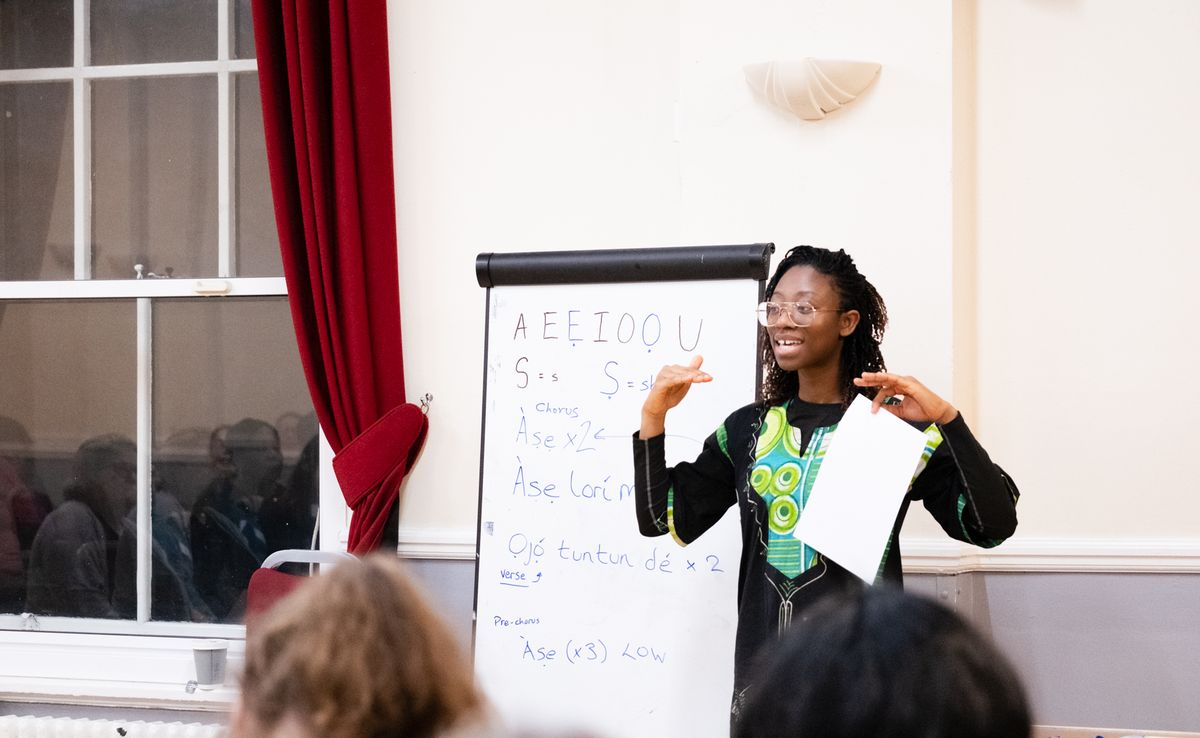 Aanu from the music team leading a rehearsal at a flip chart