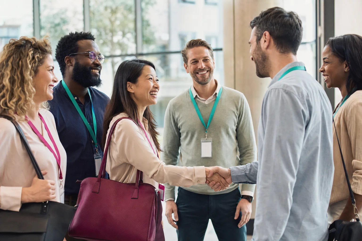 Two teams meeting for the first time and shaking hands in a bright office
