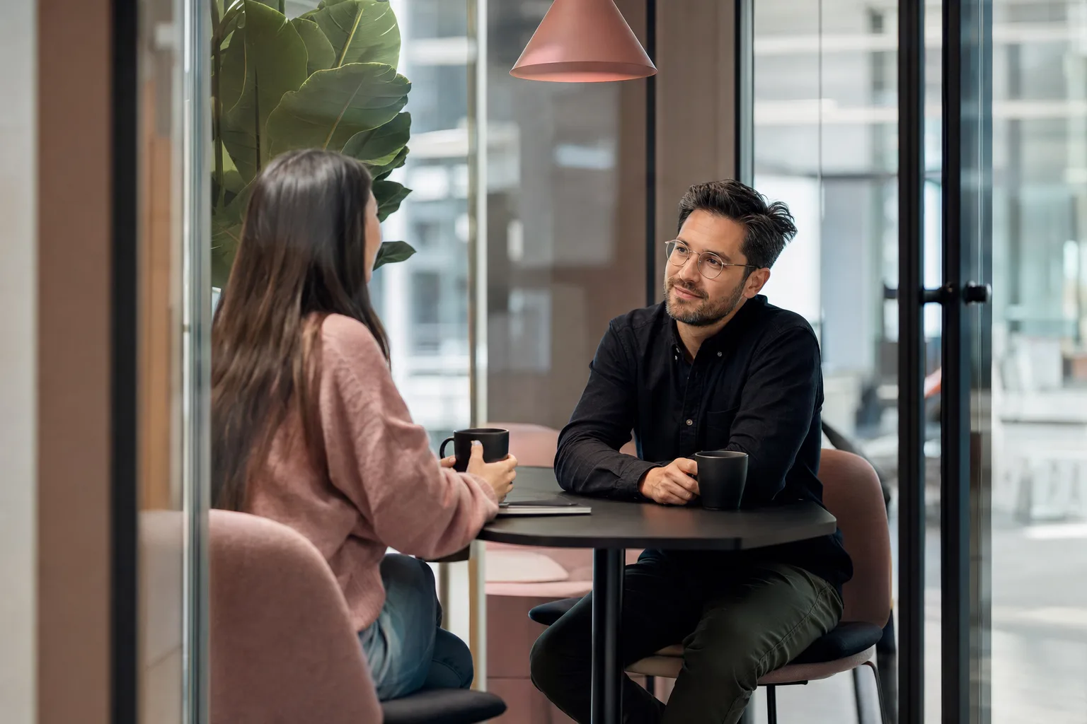 A manager having a relaxed one-on-one with a team member over coffee