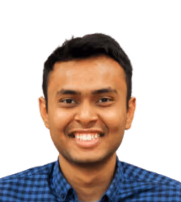Smiling man with short black hair wearing a blue checkered shirt.