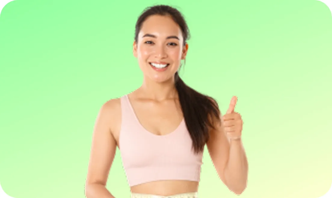 Smiling woman in a pink sports top giving a thumbs-up gesture against a green gradient background.