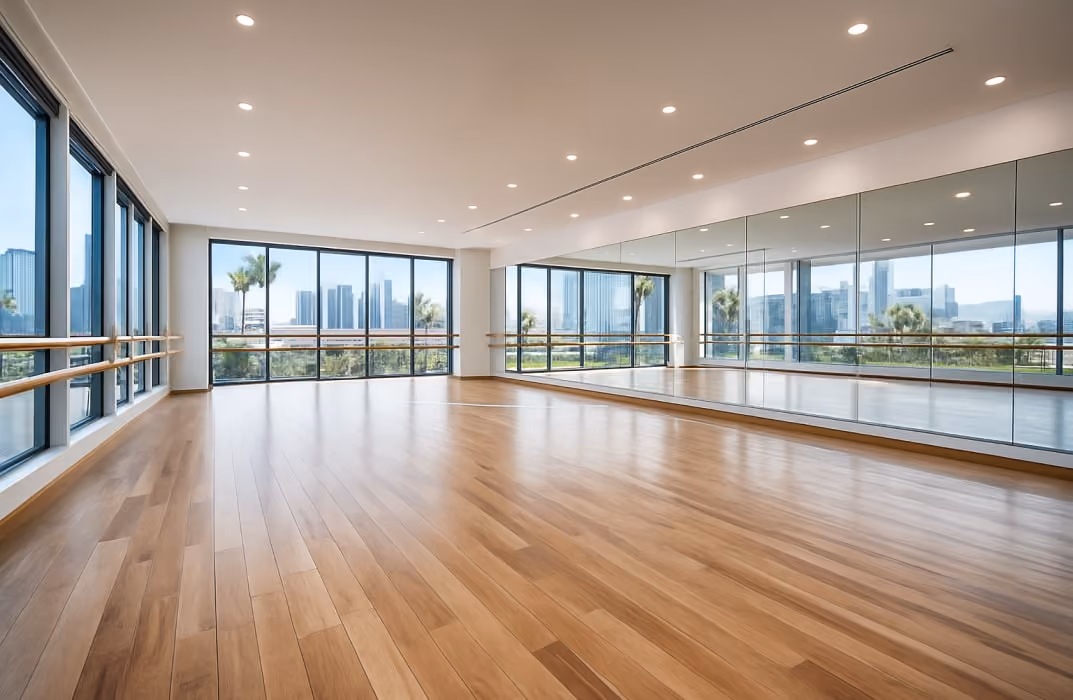 A clean, open dance studio floor with large mirrors, wood flooring, and bright lighting — possibly a shot from Los Angeles to reflect U.S. appeal.