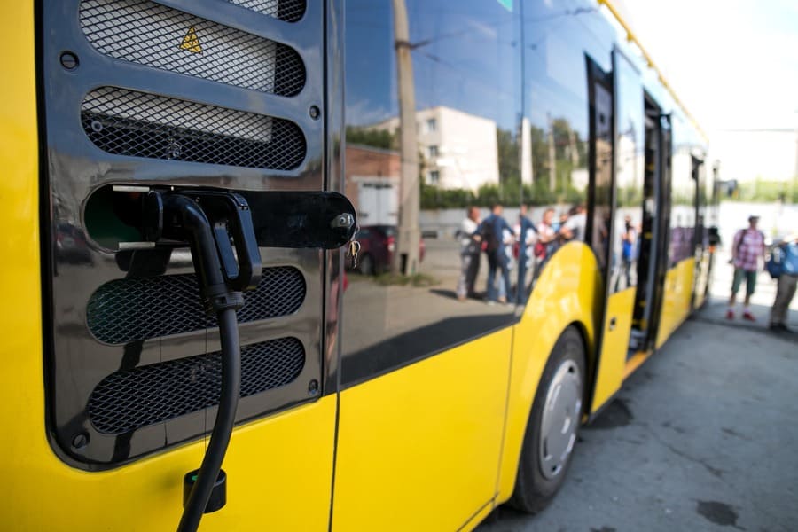 Electric yellow bus charging with plug