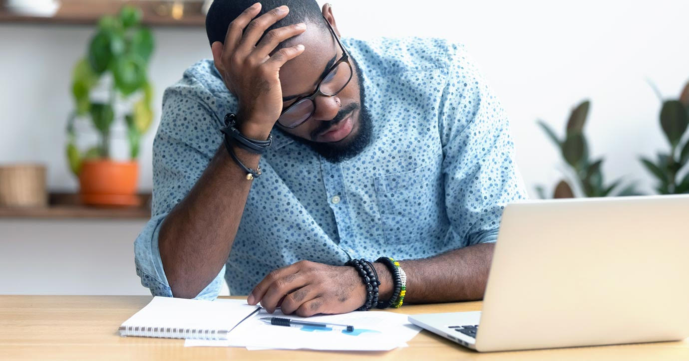 Man staring at computer at desk