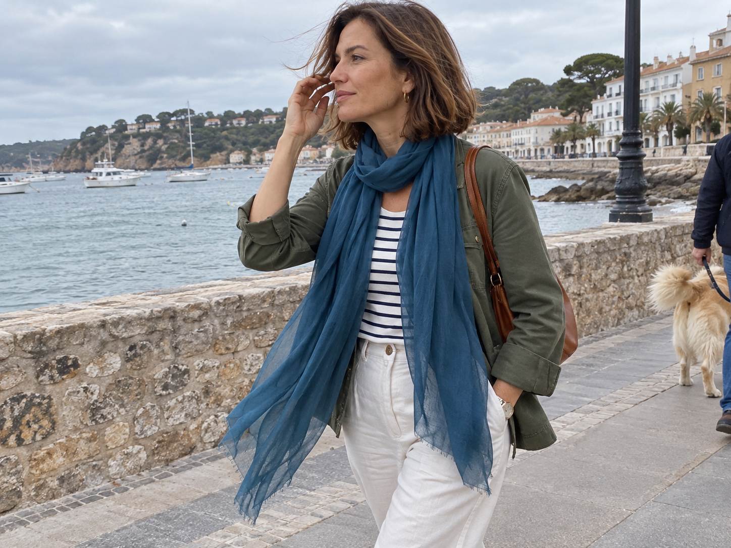 Fashion blogger wearing a blue Featherlight cashmere scarf and an olive jacket on a seaside walk.